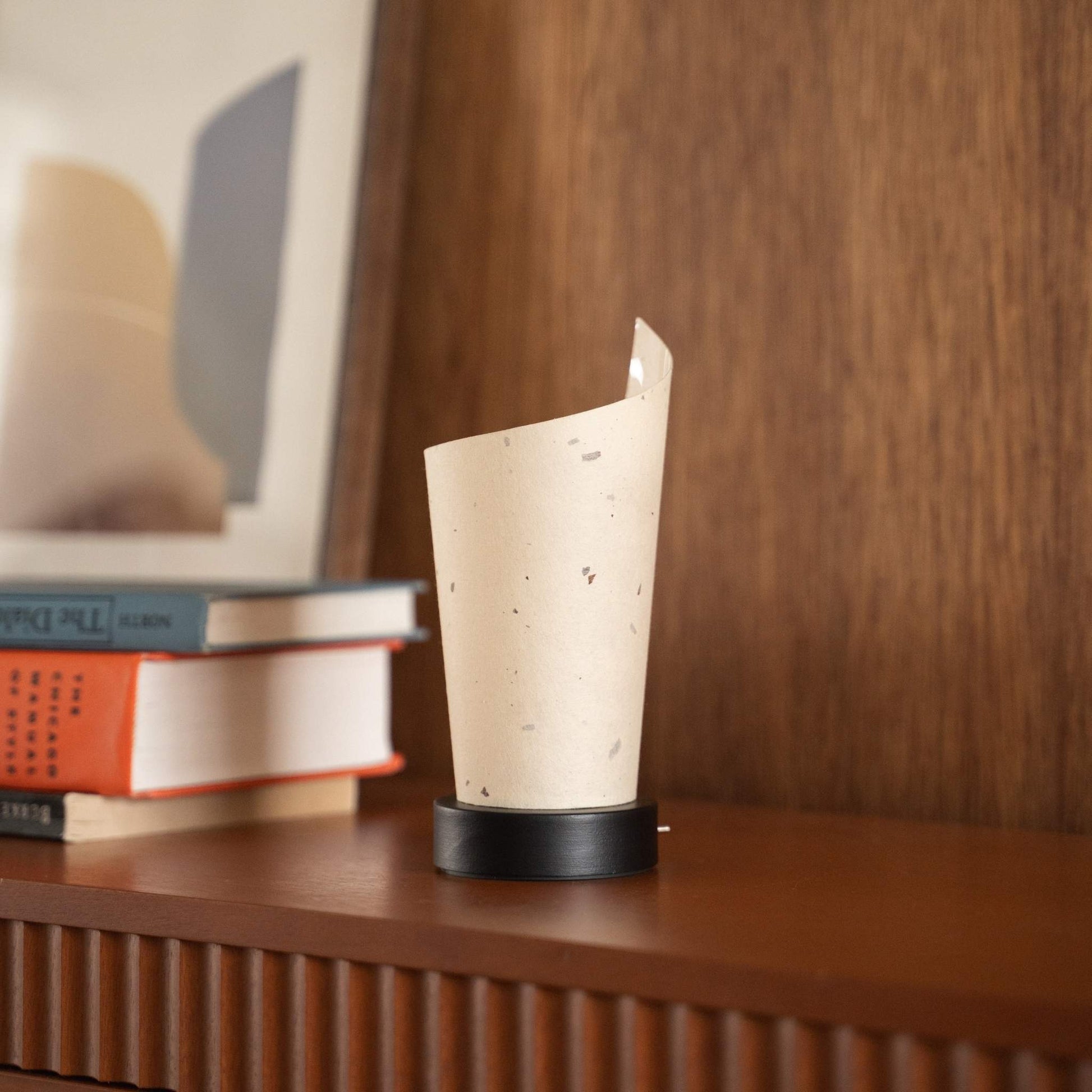 Close-up of an unlit Japanese paper table lamp "Maki" highlighting its natural flecks and wabi sabi aesthetic on a console.