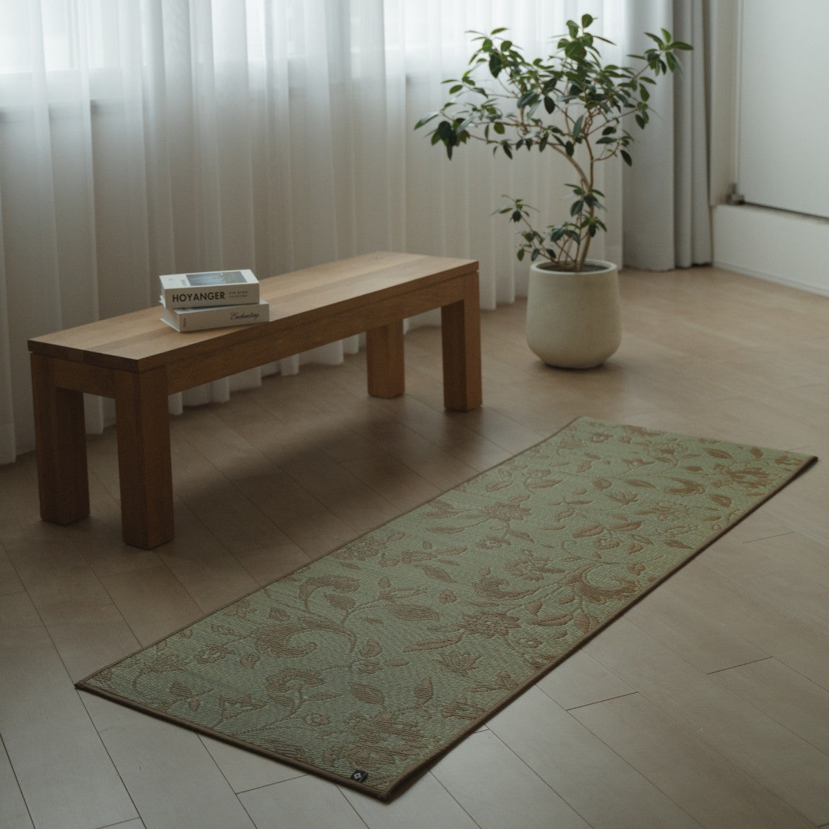 Japanse Tatami Yogamat "Sarasa" Beige met botanisch patroon op een houten vloer in een minimalistische woonkamer voor thuisoefeningen.