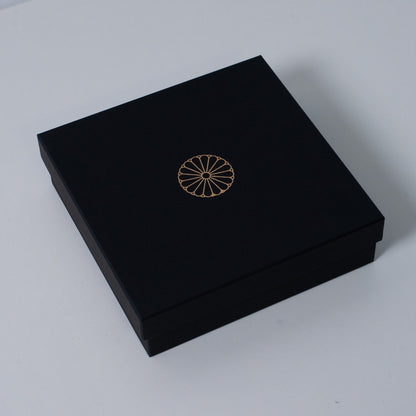 Closed slim black Ninshu's gift box for Japanese incense holder pottery, featuring a gold imperial chrysanthemum crest on the lid.