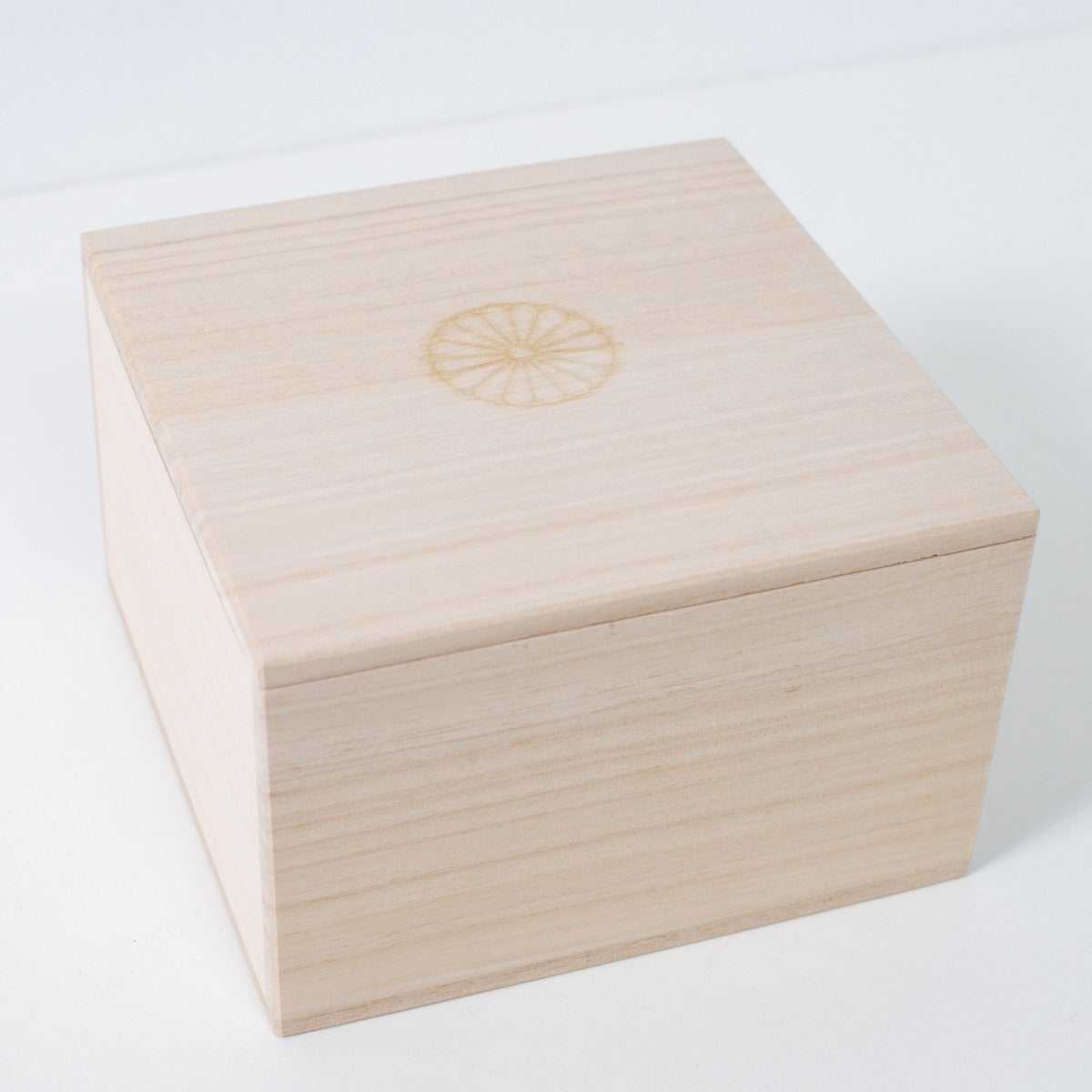 Geschlossene quadratische Ninshu Holz-Geschenkbox für japanische Matcha-Schale aus Keramik, mit gebrandetem Chrysanthemen-Wappen in der Mitte des Deckels.