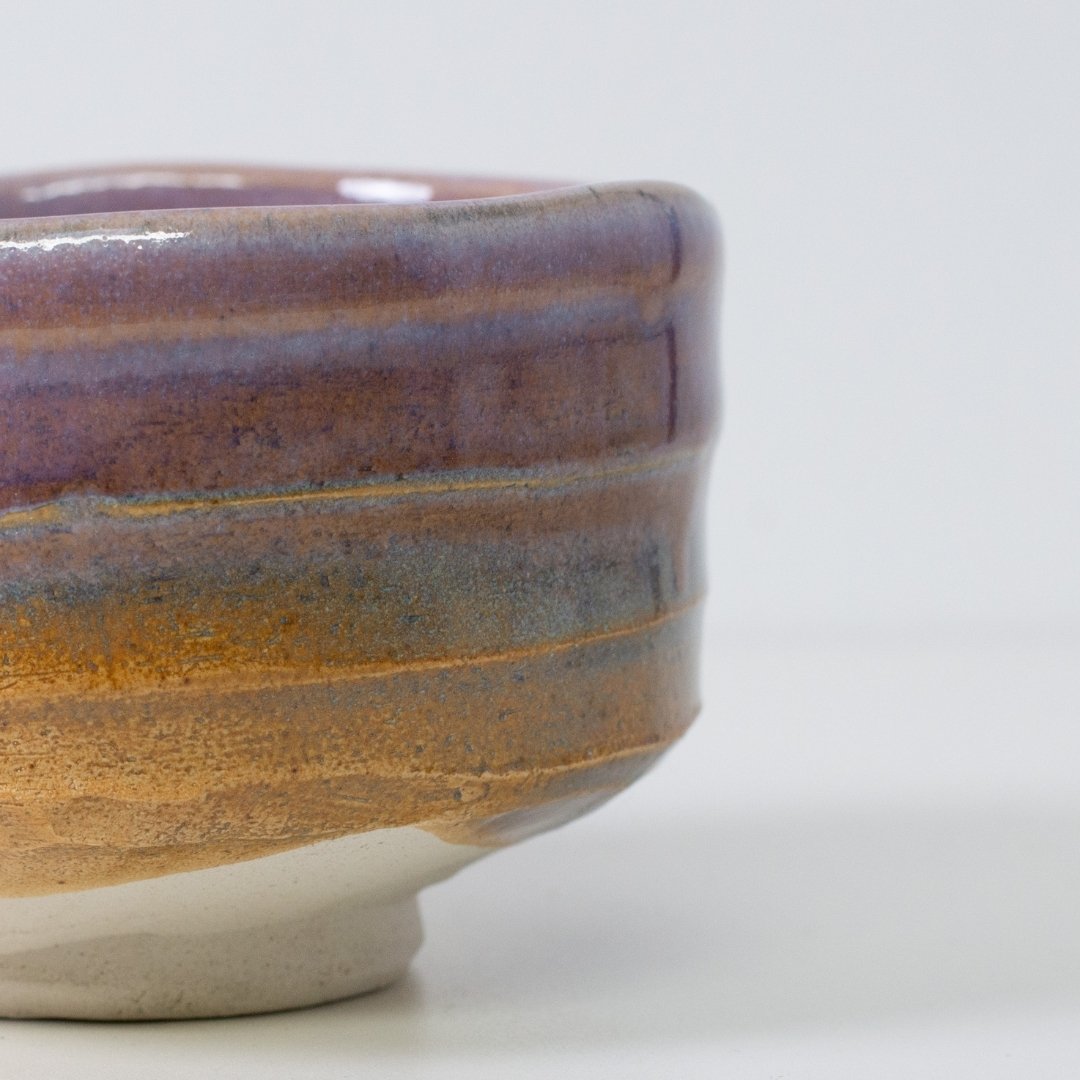 Detail of "Pale Violet Haze" matcha chawan bowl highlighting the organic gradient where purple glaze meets the textured Shino clay.