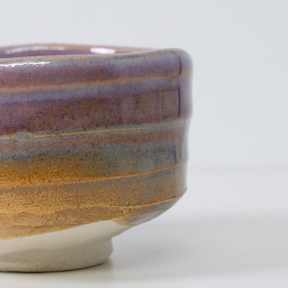 Detail of "Pale Violet Haze" matcha chawan bowl highlighting the organic gradient where purple glaze meets the textured Shino clay.