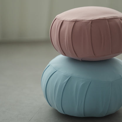 Rose and calm blue Japanese meditation cushion zafu, stacked together in a Japandi room for a relaxing home yoga session.