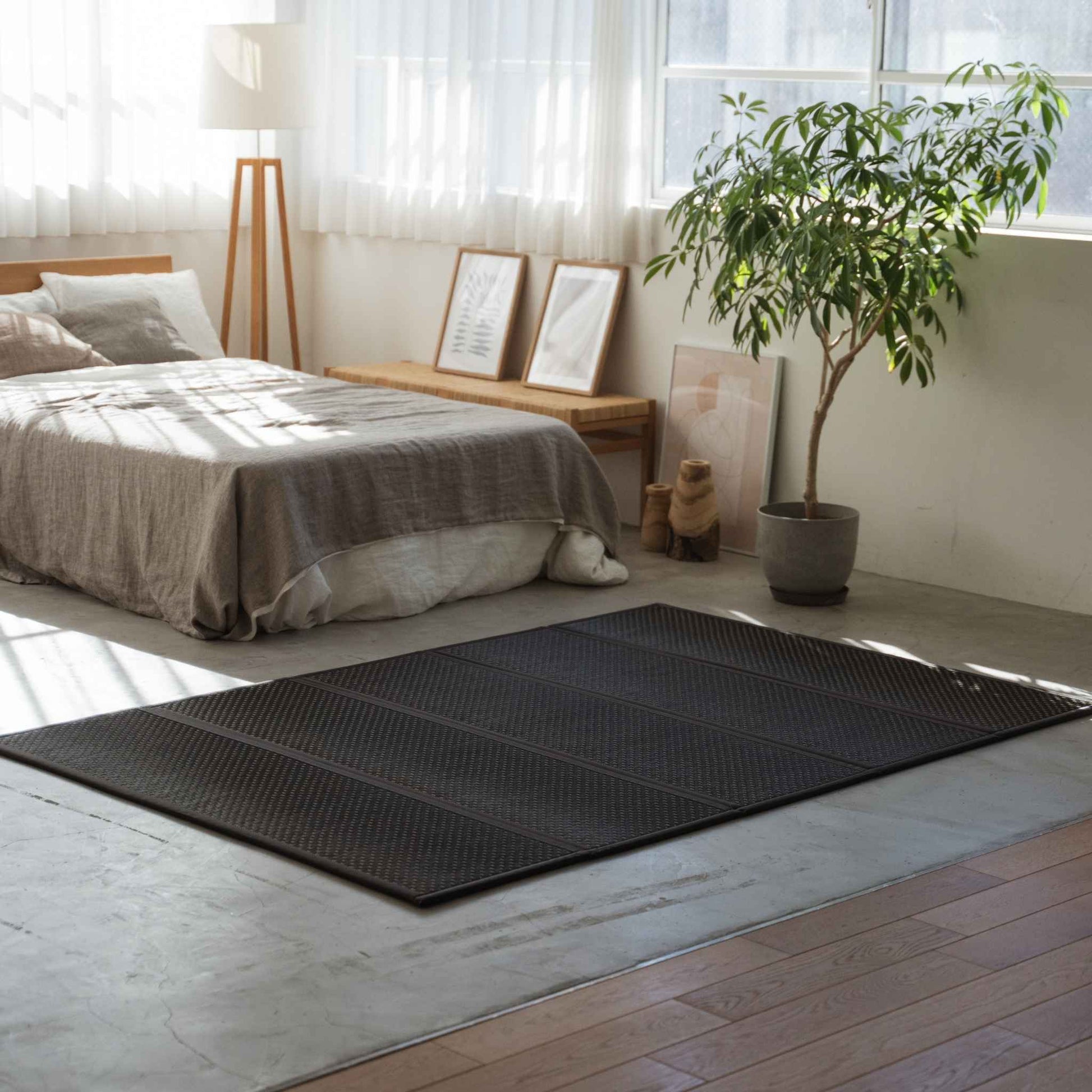 Double size black tatami mattress laid on a bedroom floor creating a stylish and breathable sleeping space.