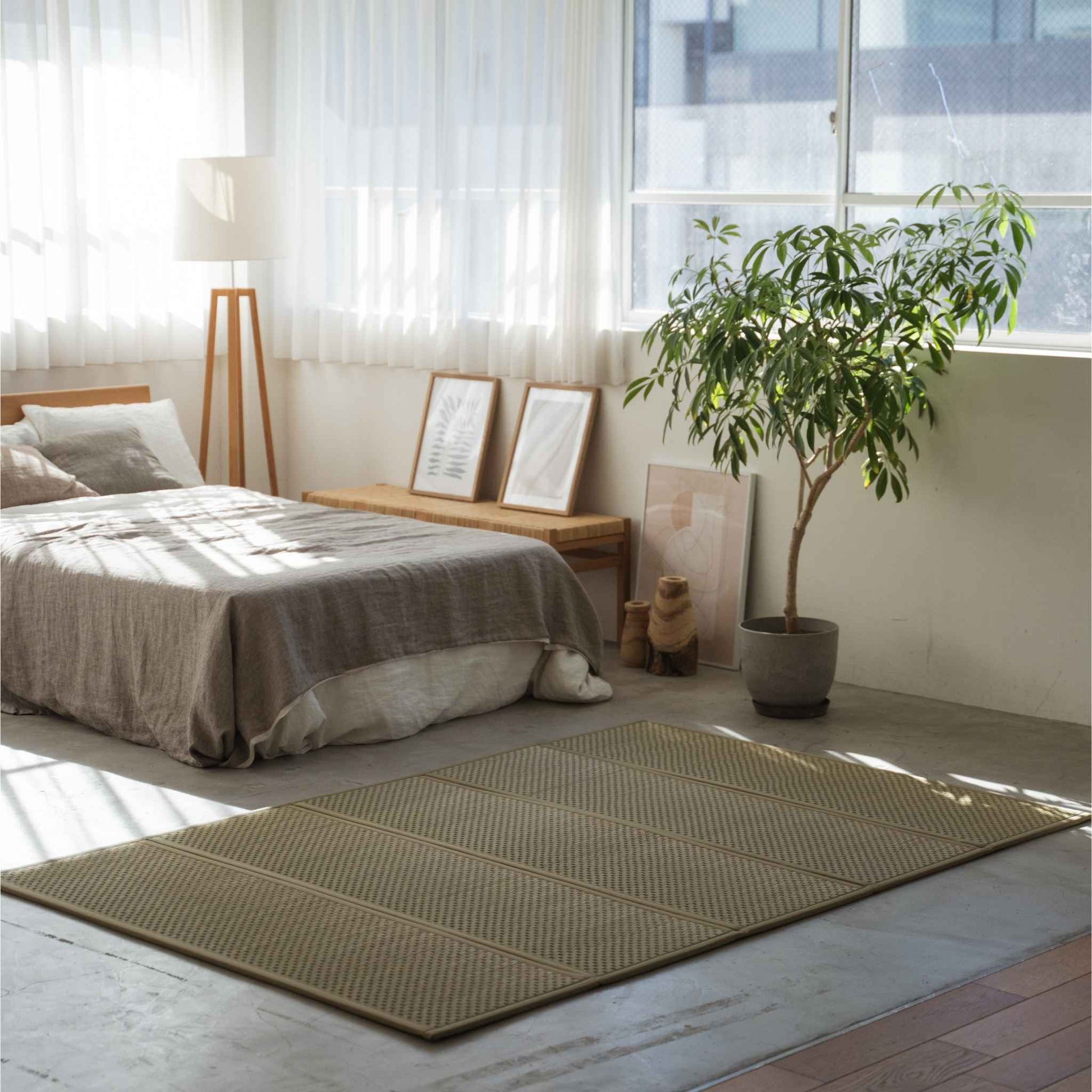 Double size tatami mat spread on a sunlit bedroom floor creating a natural meditation space and zen vibe.
