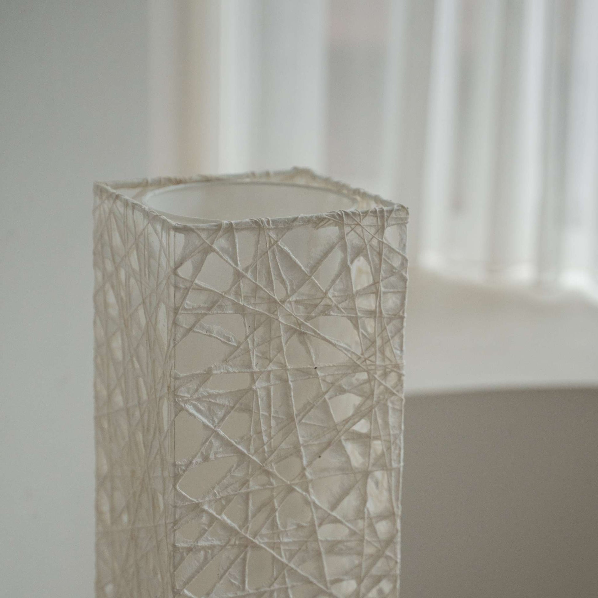 Detail shot of the translucent white Melook paper texture showing the fibrous web pattern of the lamp shade