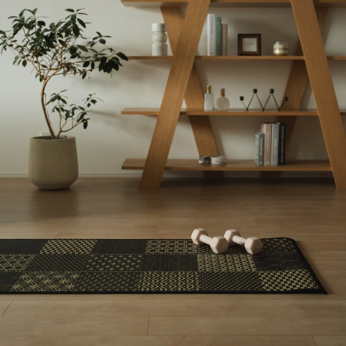 Japanese Tatami Yoga Mattress "Ed Plain" Black with dumbbells in a Japandi-style living room for a modern home workout.