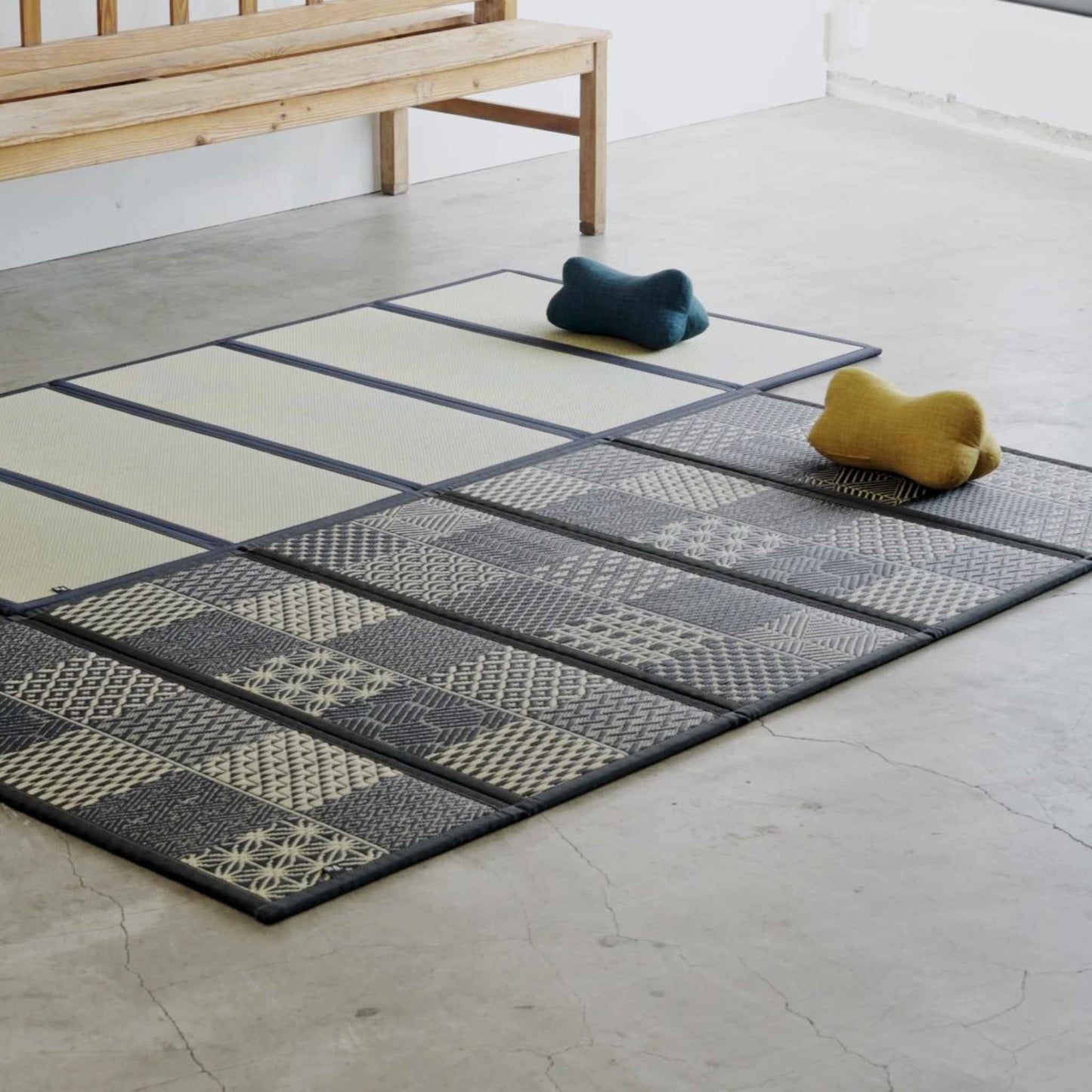 Two five panel tatami mats laid on a concrete floor with cushions creating a relaxing zen space.