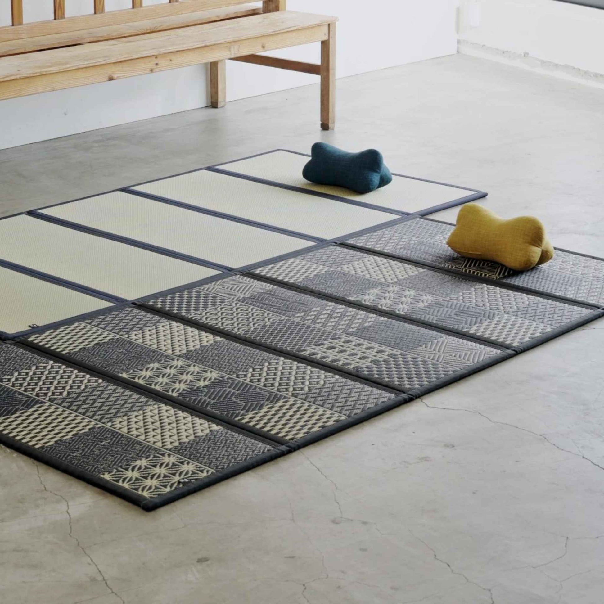 Two five panel tatami mats laid on a concrete floor with cushions creating a relaxing zen space.