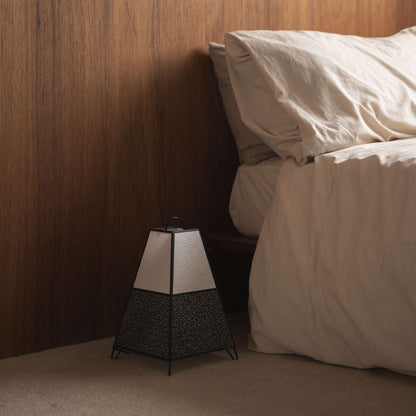 Unlit Japanese paper floor lamp KURA Small with a Seigaiha pattern placed beside a bed in a Japandi style bedroom.