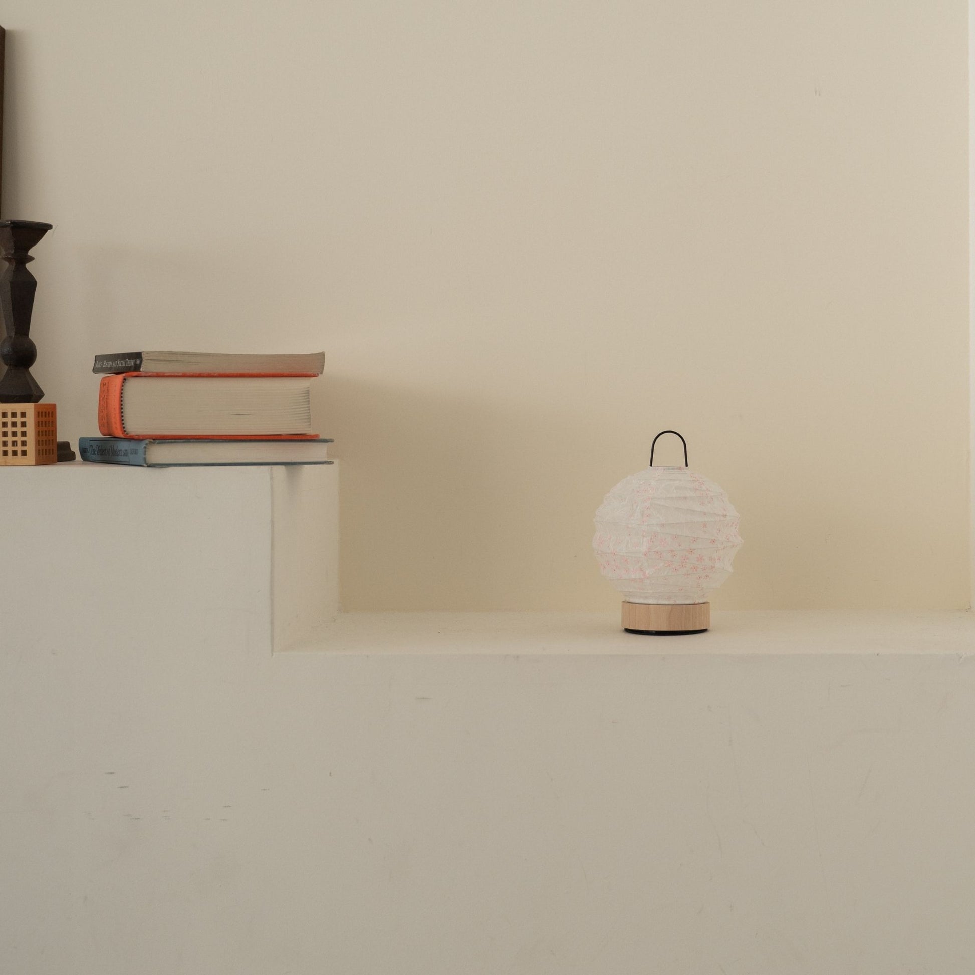 Unlit round Japanese paper table lamp "Yuhi" Sakura placed on a white console table in a minimalist Japandi living room.