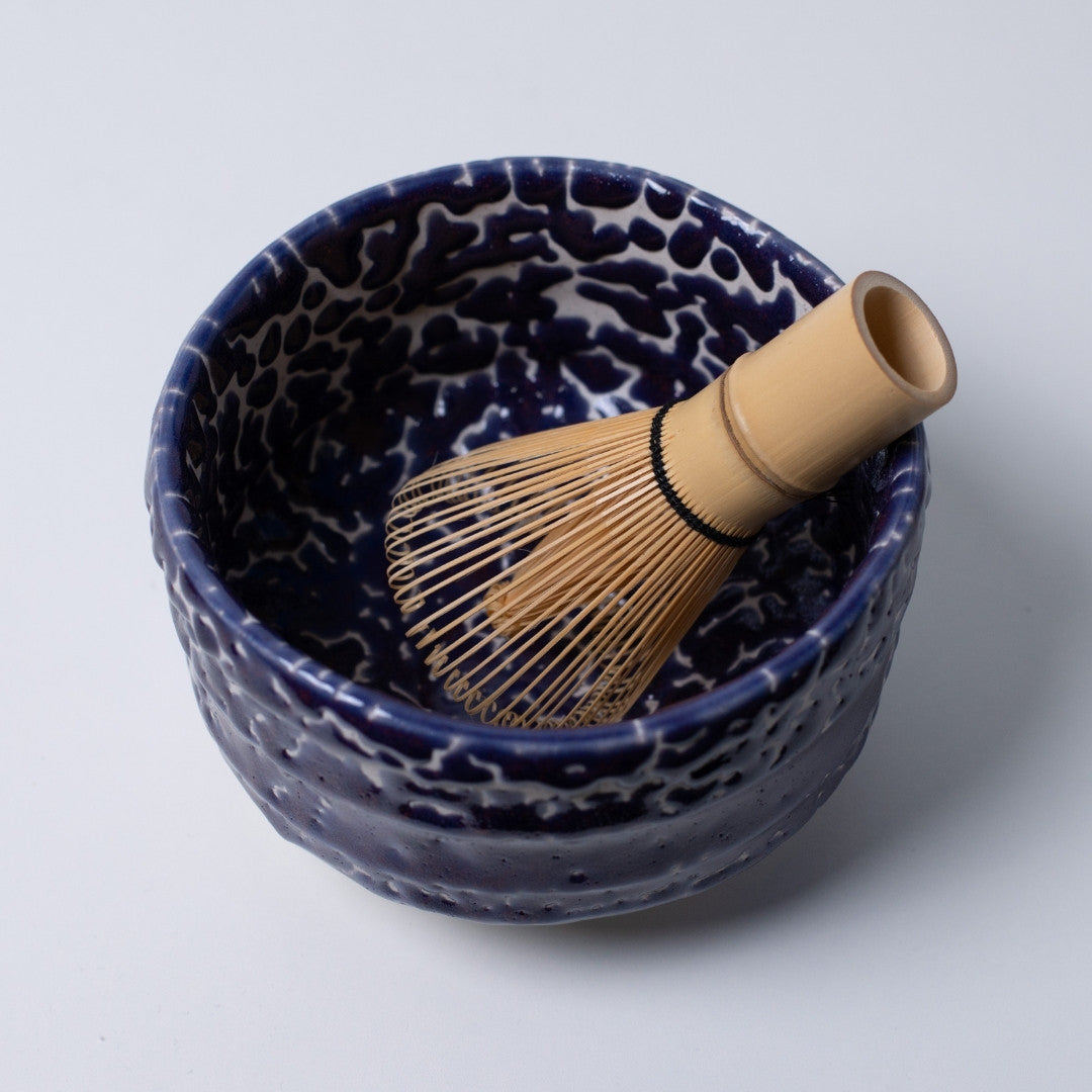 Interior view of the "Midnight Blue Kairagi" Japanese matcha bowl with a bamboo tea whisk, showing the deep blue hue for meditative tea rituals.