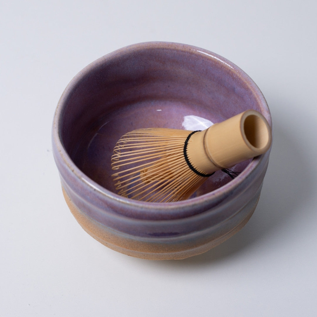 Interior view of the "Pale Violet Haze" Japanese matcha bowl with a bamboo whisk, creating a visual harmony of soft purple and tea green.
