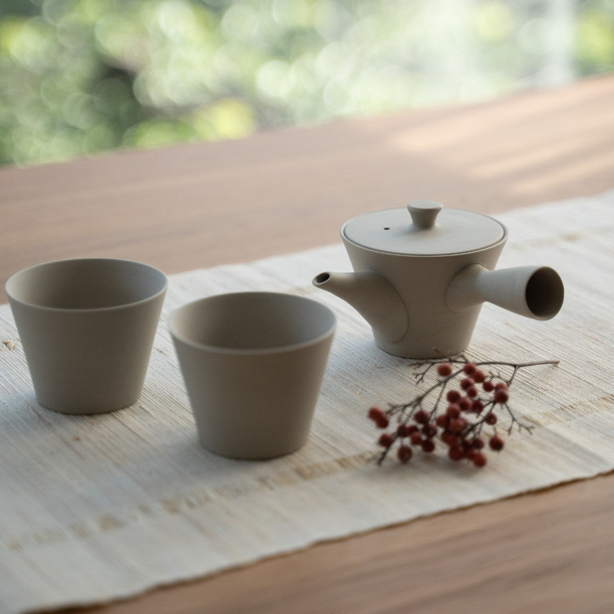 Hvid japansk tekande "Sencha" og japanske tekopper på en linneddug til teelskere, der skaber en zen-æstetik.