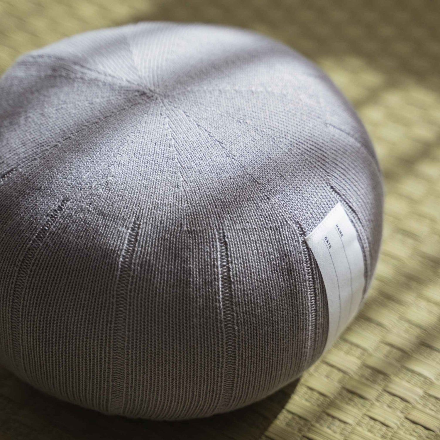 Lagoon gray zafu meditation cushion handcrafted from organic cotton placed on a traditional tatami mat.