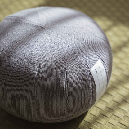 Lagoon gray zafu meditation cushion handcrafted from organic cotton placed on a traditional tatami mat.
